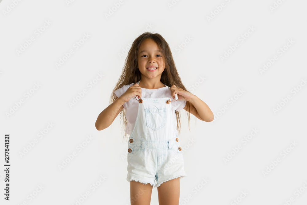 Beautiful female half-length portrait isolated on white studio background. Little emotional asian girl wearing white. Facial expression, human emotions, advertising, sales concept. Wondered and happy. Beautiful female half-length portrait isolated on white studio background. Little emotional asian girl wearing white. Facial expression, human emotions, advertising, sales concept. Wondered and happy.