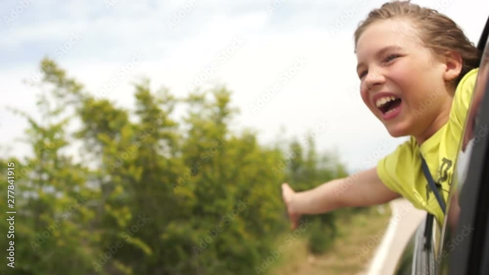 Adorable little boy leaning out of car window. Happy family vacation, a boy travels with his parents along the sea coast Adorable little boy leaning out of car window. Happy family vacation, a boy travels with his parents along the sea coast