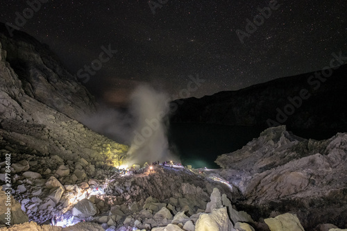 Scenery of crater with smoke of sulfur with blue flame at night