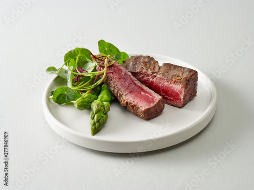 Plate of beef wagyu steak meat with herbs and asparagus
