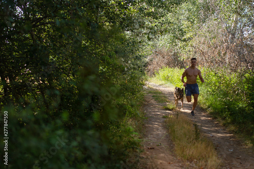 runner running across the field with his dog