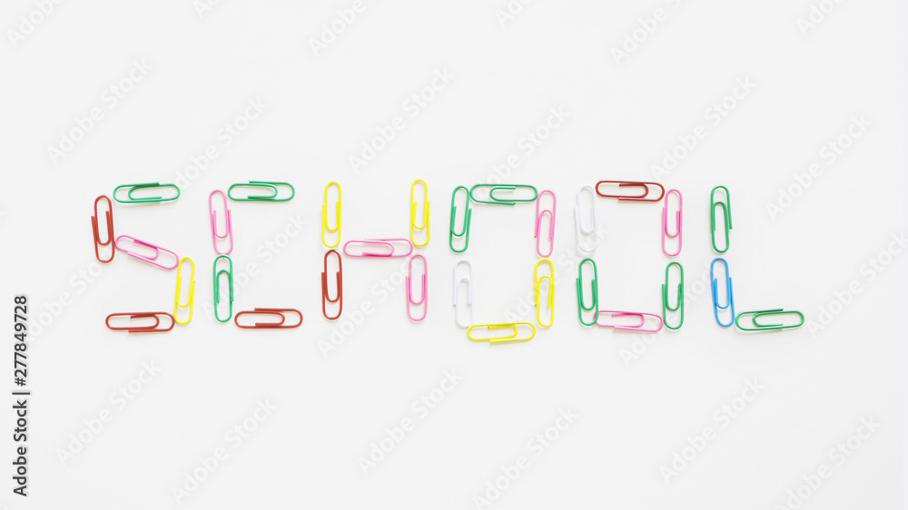 Elevated view of school word made up of colorful paper clips on white backdrop
