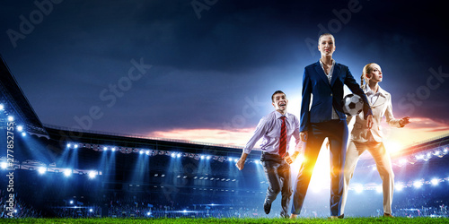 Business team on football stadium. Mixed media © Sergey Nivens