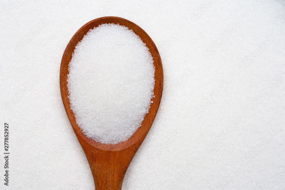 Wooden spoon with white granulated sugar. Wooden spoon with white granulated sugar.