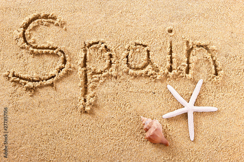 Spain word written in sand sign writing drawing drawn on a sunny spanish summer beach with starfish holiday vacation travel destination message photo