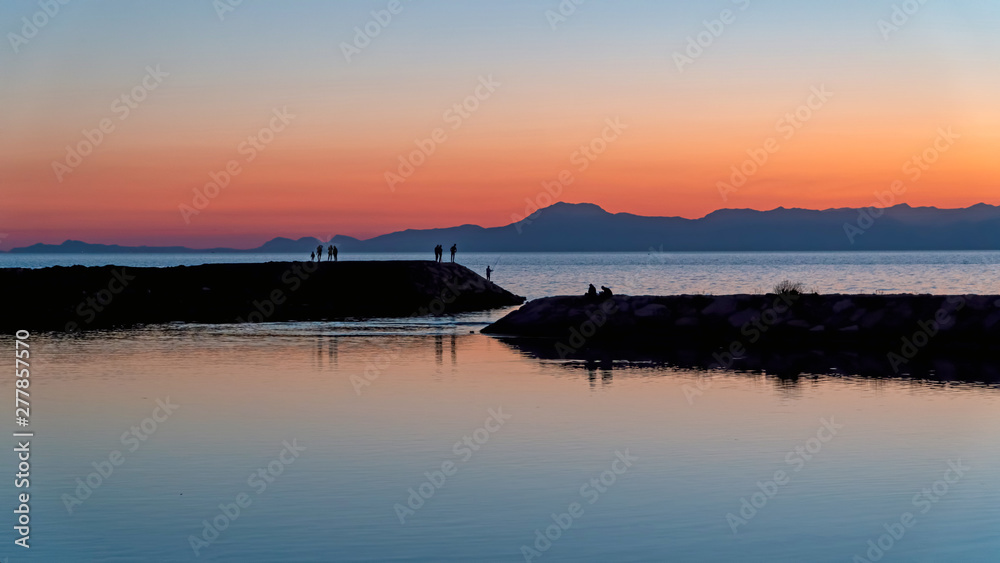 Unidentified people silhouette at Side beach with mediterranean sea during sunset, Antalya, Turkey