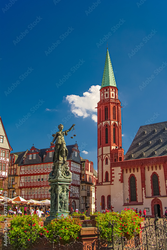 Statue a judge woman with scales and sword with old traditional wooden made houses in downtown of Frankfurt, Germany, details, closeup