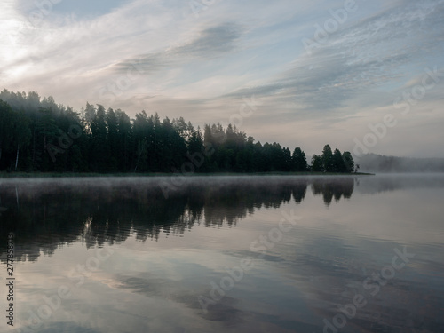 Foggy and mystical lake landscape before sunrise. All silhouettes are blurry and unclear. Vaidavas lake, Latvia © ANDA