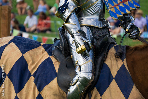 A medieval knight sitting on a horse wearing shining armour