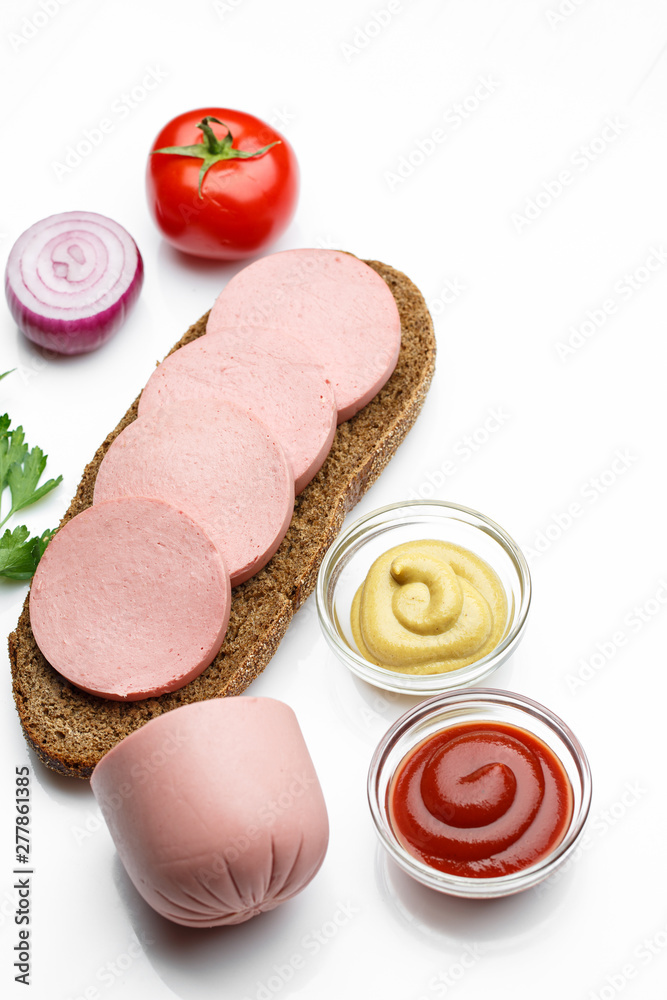 sliced boiled sausage with bread, tomatoes, onion parsley on white background sliced boiled sausage with bread, tomatoes, onion parsley on white background
