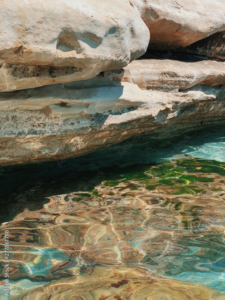 Sea water under the rock. Sea water washes the stones. Glare from water on rocks Sea water under the rock. Sea water washes the stones. Glare from water on rocks