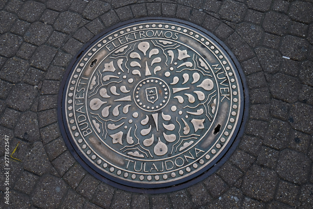 An iron manhole cover in a street of Budapest, Hungary