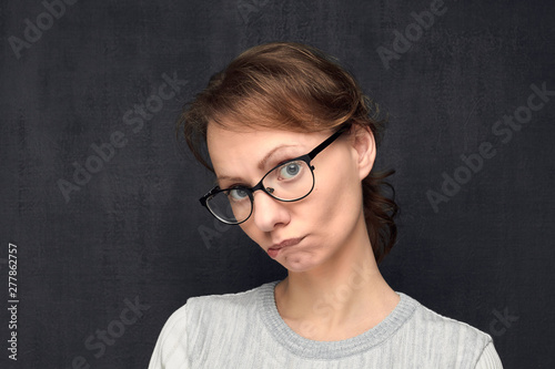 Portrait of upset and funny woman with glasses