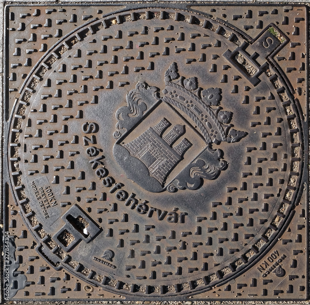 An iron manhole cover in a street of Szekesfehervar, Hungary