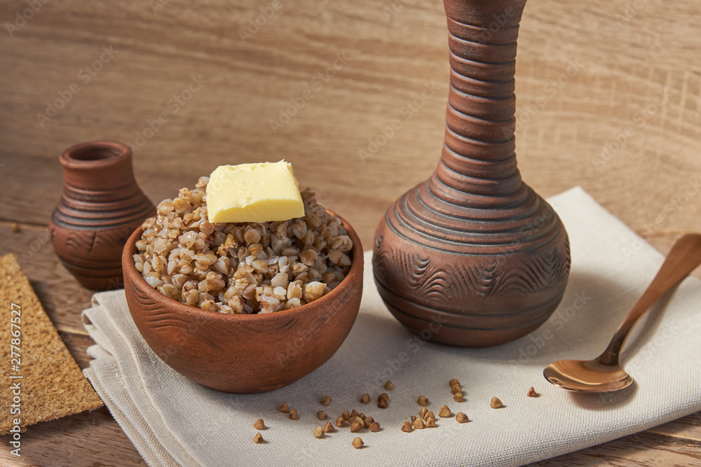 cooked buckwheat with a slice of butter served with rye crisps on wooden table cooked buckwheat with a slice of butter served with rye crisps on wooden table