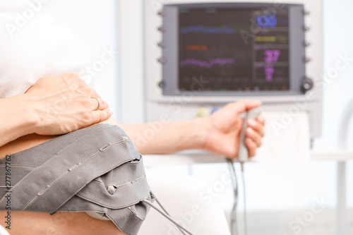 Pregnant woman performing cardiotocography CTG monitoring fetal heartbeat