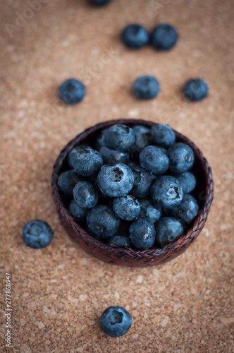 Freshly picked blueberries in woven natural screwpine leaf bowl. Juicy and fresh blueberries with on rustic table. Bilberry on wooden Background. Blueberry antioxidant. Concept for healthy eating.