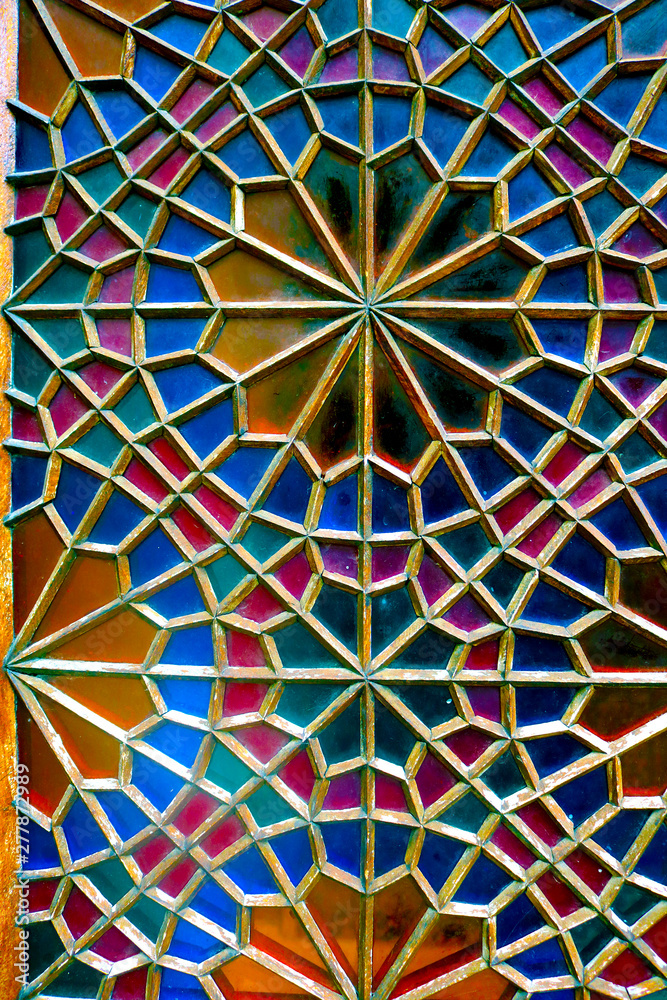 Traditional oriental window pattern made of little colorful glasses. Detail of the stained glass window. A geometric pattern on the side of the Palace of Shaki Khans. Sheki, Azerbaijan.