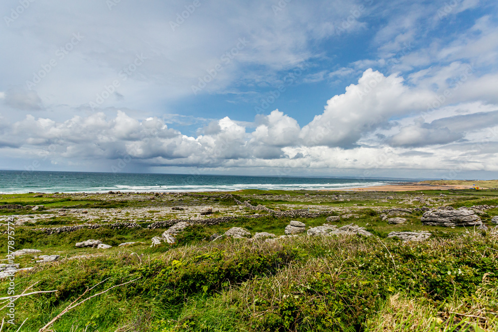 Beautiful landscape of the coast with limestone rocks with grass next to the Fanore beach, geosite and geopark, Wild Atlantic Way, spring day in County Clare in Ireland Beautiful landscape of the coast with limestone rocks with grass next to the Fanore beach, geosite and geopark, Wild Atlantic Way, spring day in County Clare in Ireland
