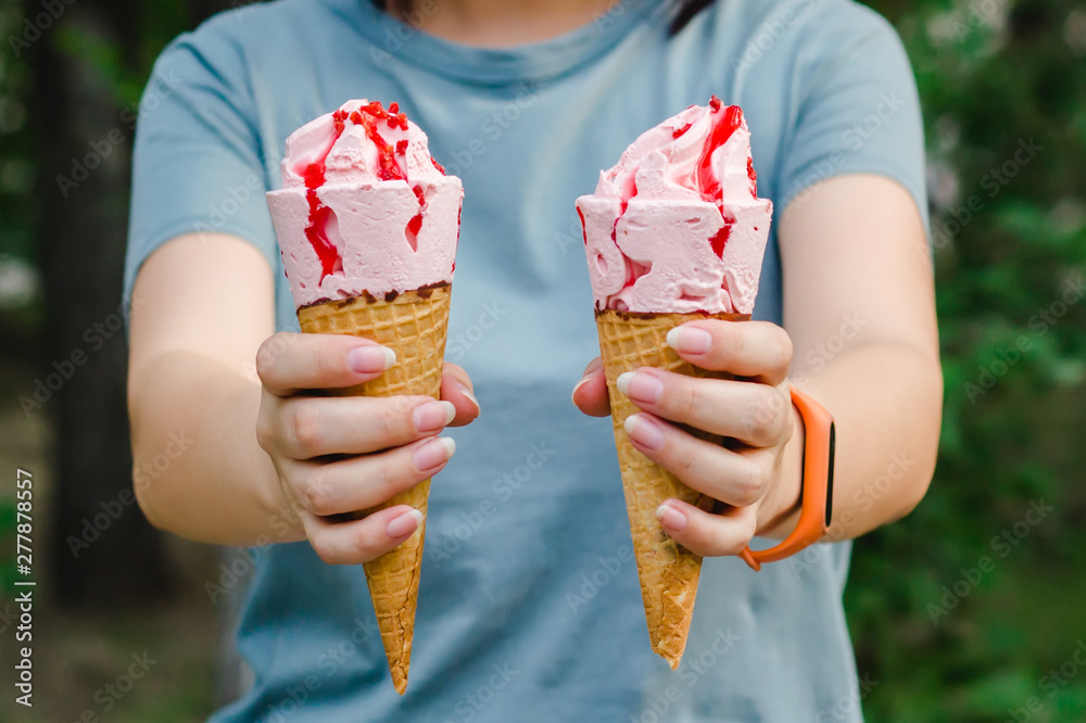 Young woman holding two ice cream in her hands.
