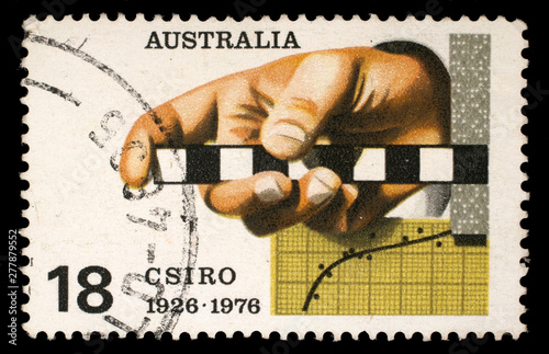 Stamp printed in AUSTRALIA shows the Survey Rule, Graph, Punched Tape, Commonwealth Scientific and Industrial Research Organization, 50th anniversary, circa 1976 photo