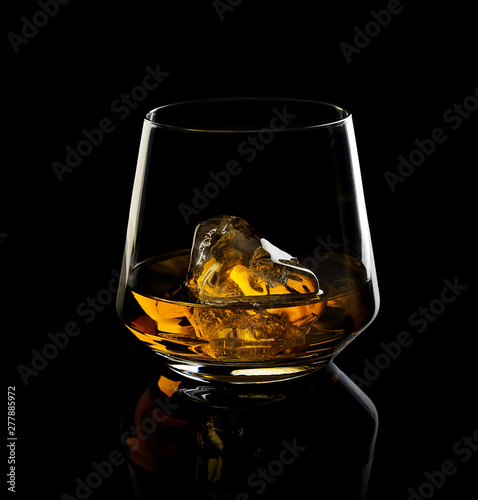 glass of whiskey with ice on a black background
