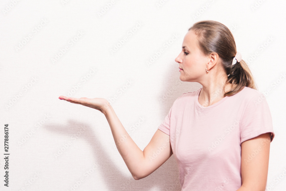 Woman surprise showing product .Beautiful girl pointing to the side . Presentation of your product. Expressive facial expressions Woman surprise showing product .Beautiful girl pointing to the side . Presentation of your product. Expressive facial expressions
