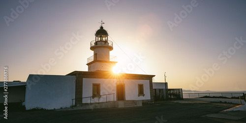 lighthouse in beautiful Mediterranean landscape sunset over the mountains