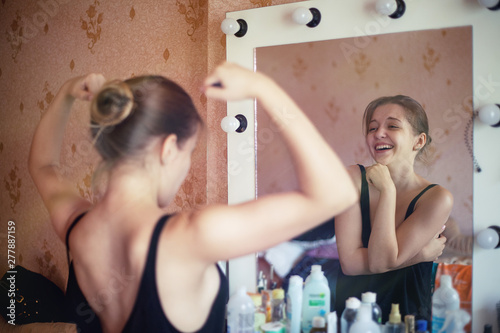 Cuadro en lienzo Sporty girl ironically laughs from her reflection in the mirror