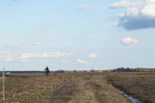 A man is riding a bicycle in the field