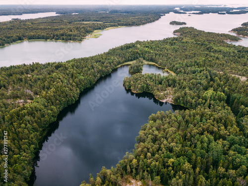 Aerial view of blue lakes and green forests on a sunny summer day in Pentala island museum, Finland