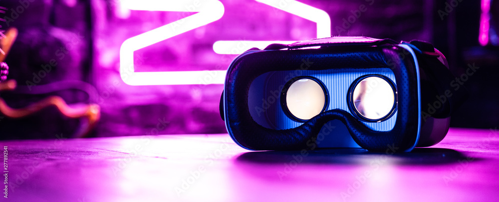 VR 3d 360 headset glasses goggles in futuristic purple neon light on table  desk, virtual augmented ar reality innovative experience digital technology  background concept, copy space wide photo banner Photos | Adobe Stock