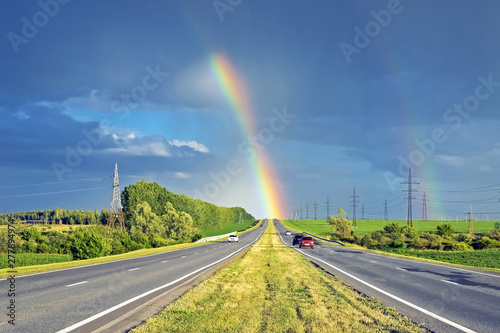 amazingly beautiful view of the rainbow on the horizon of the highway for cars © serhio777