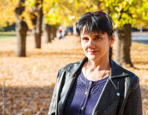 young brunette smiling woman on a walk in the park