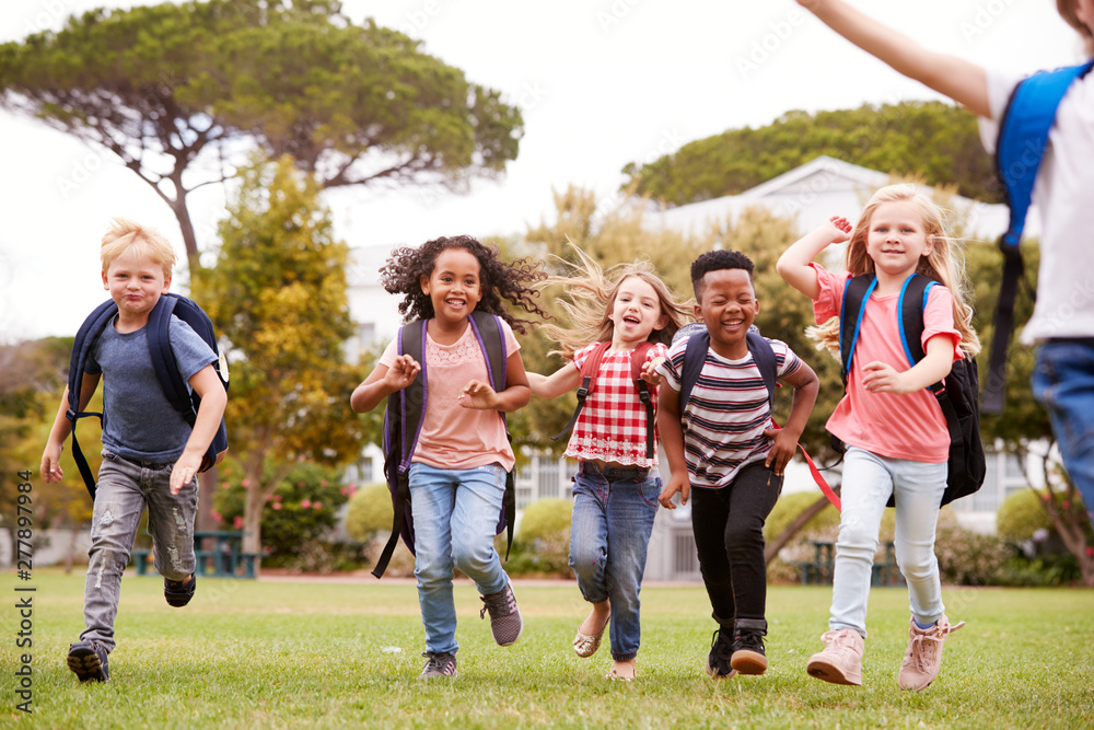 Excited Elementary School Pupils Running Across Field At Break Time Excited Elementary School Pupils Running Across Field At Break Time