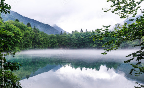 Fog spreads over the surface of the blue karst lake Cerik-Kel in cloudy weather, Kabardino-Balkar Republic, Russia