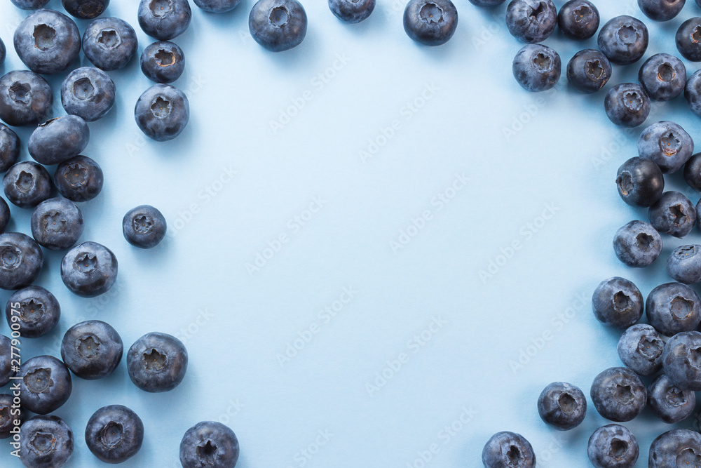 Frame made of blueberries on blue background