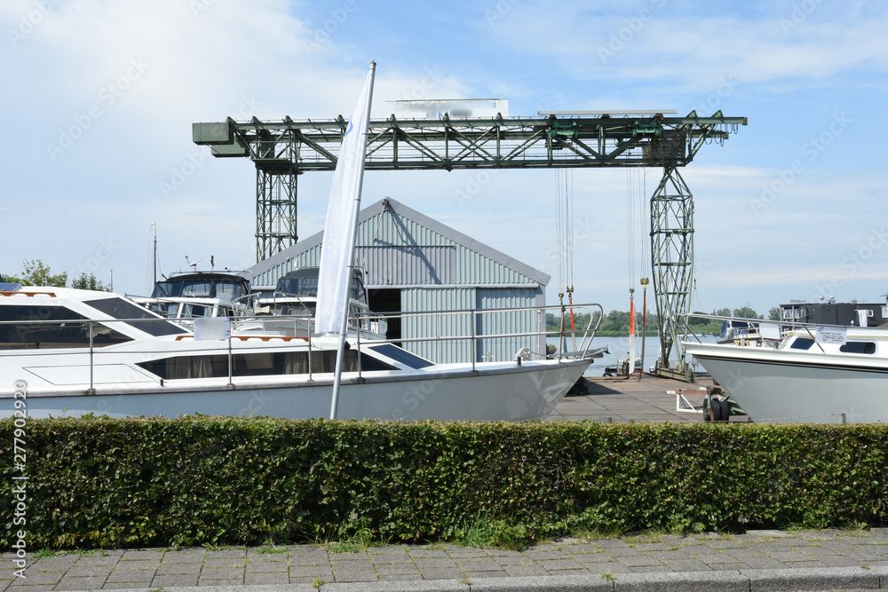 boats and crane on shipyard in small Dutch town