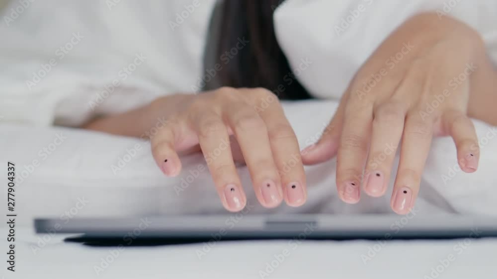 Hand touching keyboard on modern digital tablet on the bedroom Hand touching keyboard on modern digital tablet on the bedroom