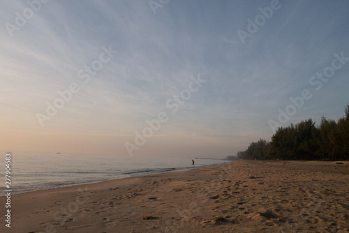 Fototapeta Naklejka Na Ścianę i Meble -  Nature background of seashore beach wave and coastline sand with sunlight water surface for holiday relaxation lifestyle concept with fisherman villager walks around
