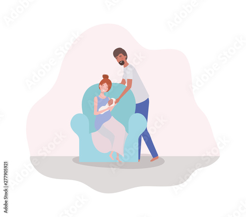 parents taking care of newborn baby in the couch