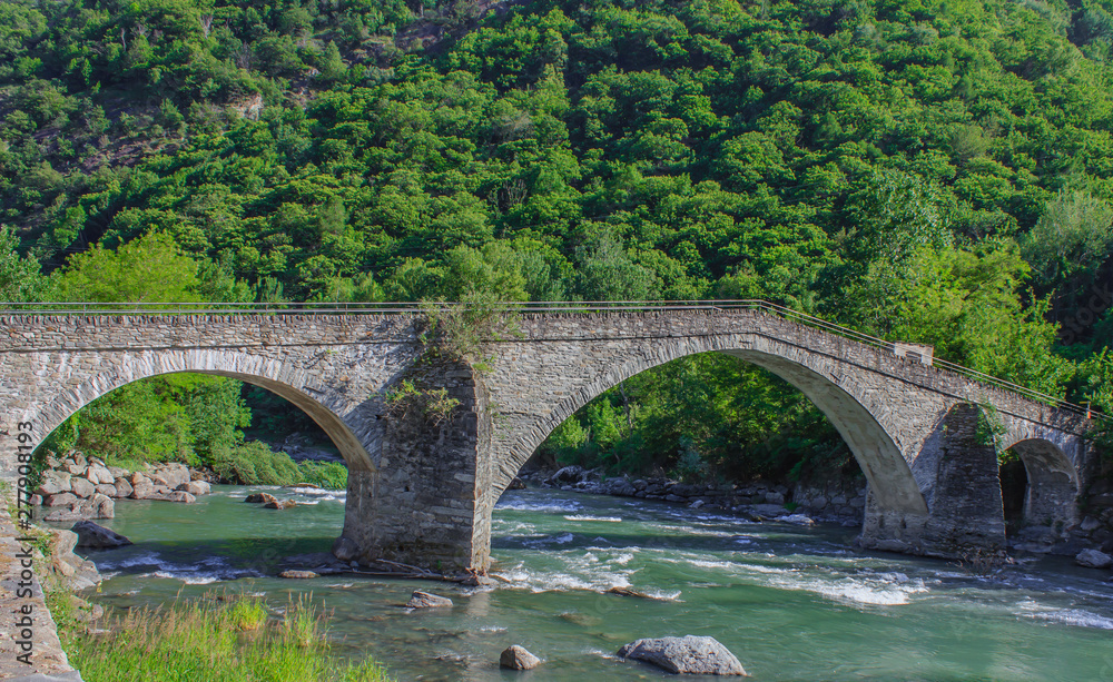  The medieval  bridge of Echallod in Arnad,  over the river  dora baltea in Aosta Valley//Italy.It is  a path of the famous way francigena, in the shape of a donkey's back,  formed by three  arches 