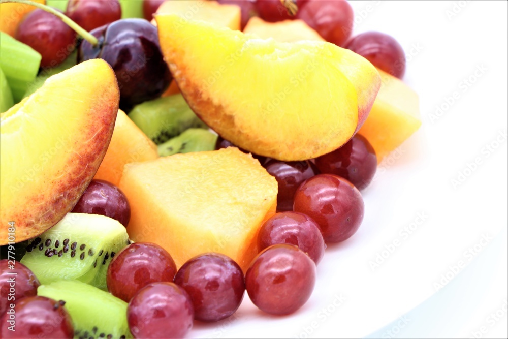 Closeup of fresh colorful fruits on white background, copy space on right Closeup of fresh colorful fruits on white background, copy space on right