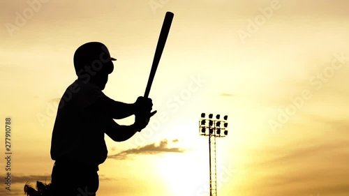Silhouette baseball player holding a baseball bat to hit the ball drills footage slow motion photo