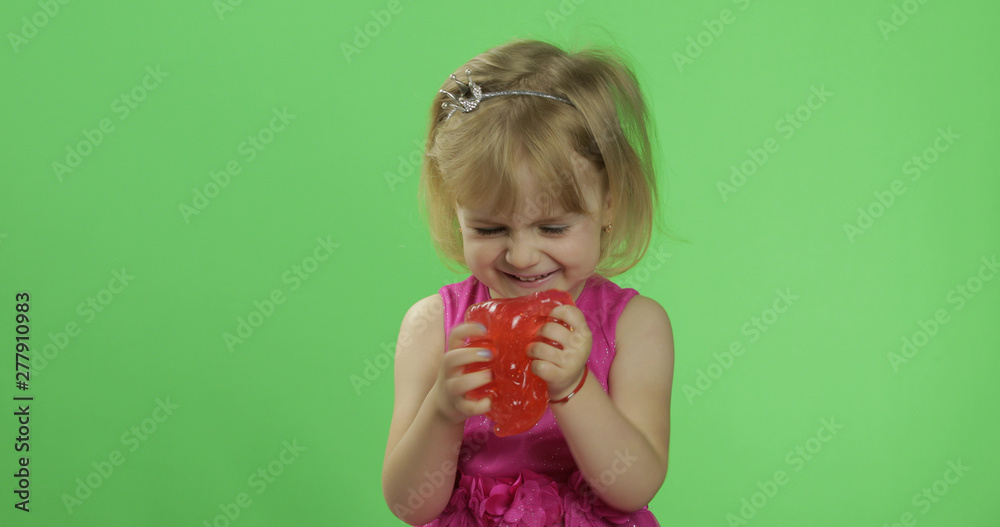 Child having fun making red slime. Kid playing with hand made toy slime Child having fun making red slime. Kid playing with hand made toy slime