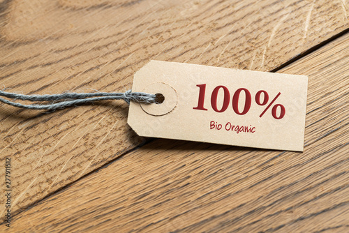 hangtag with message "100% bio organic" on wooden background
