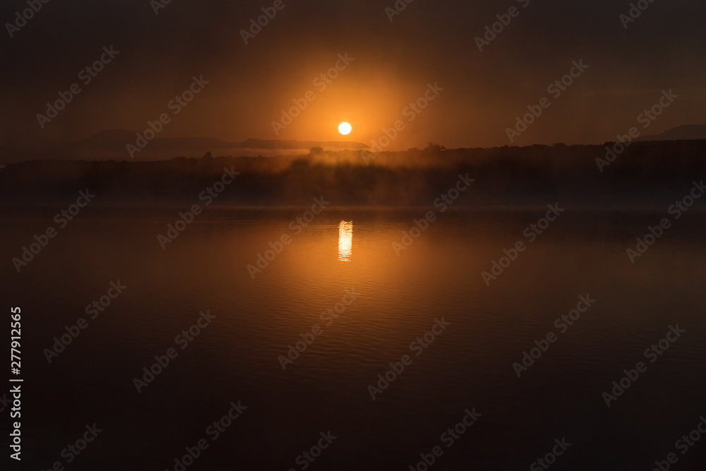 Sun rises through the fog on the dam at Vrede