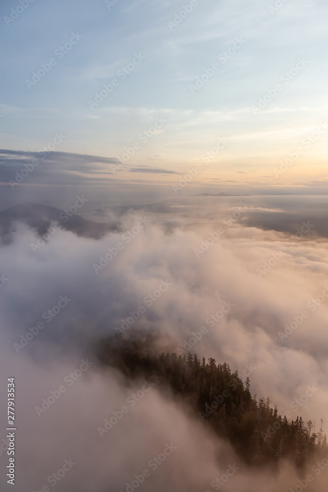 Beautiful View of Canadian Mountain Landscape covered in clouds during a vibrant summer sunset. Taken on top of St Mark's Summit, West Vancouver, British Columbia, Canada.