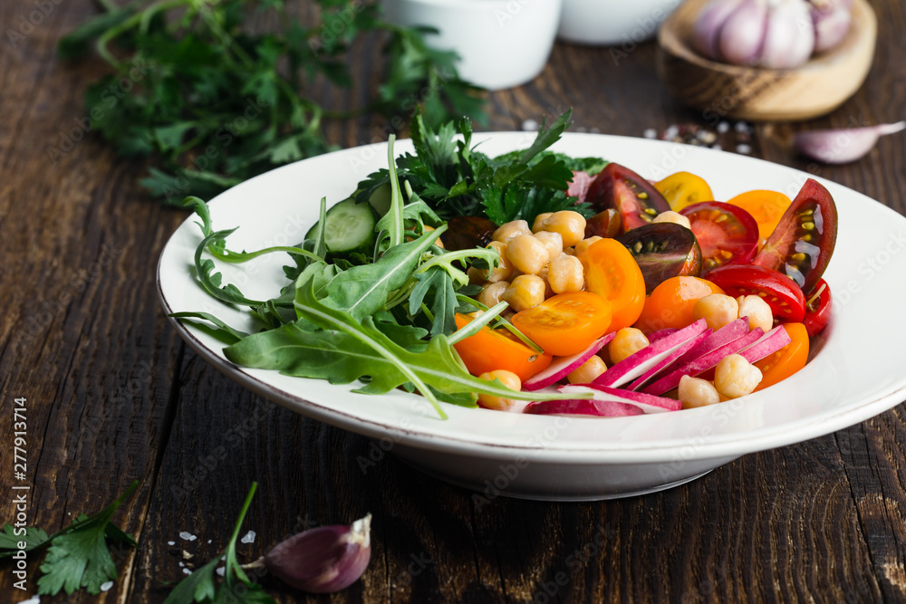 Veggie chickpeas salad with fresh vegetables and herbs, plant based meal