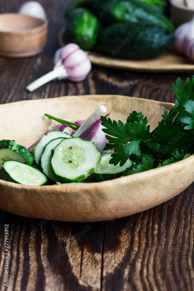 Bowl of freshly picked organic cucumbers and garlic, fresh vegetables salad Bowl of freshly picked organic cucumbers and garlic, fresh vegetables salad